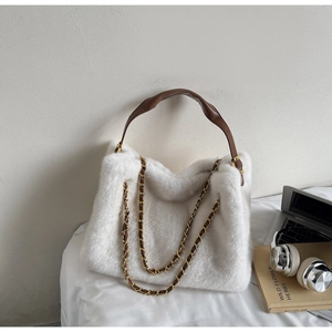 Detailed shot of plush white tote bag with brown leather handles and golden chain strap