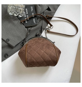 Close-up of brown suede chain bag featuring classic quilted texture and metal frame closure