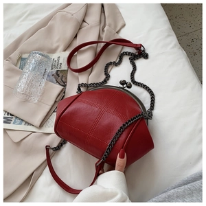Detail of red vintage shell bag with metal clasp on white bedding lifestyle background