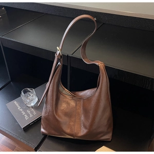 Close-up of brown oversized hobo bag showing retro crinkled leather and adjustable strap