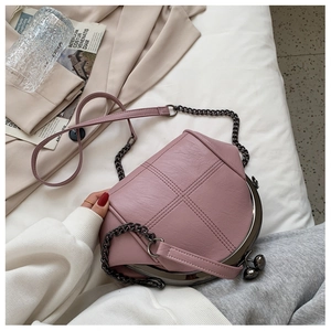 Detailed top view of a pink quilted crossbody bag on white linen with stylish props