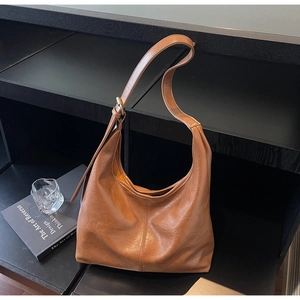 Detail view of brown large PU leather hobo bag showing vertical stitching and texture