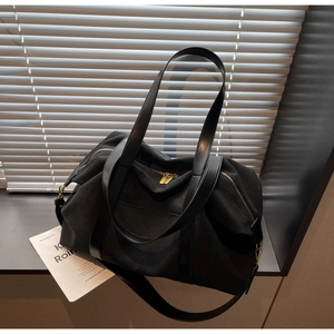Detailaufnahme der schwarzen Segeltuchtasche mit Ledergriffen und Reißverschluss