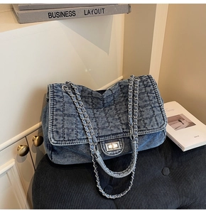 Detailed macro of vintage denim crossbody bag with quilted diamond pattern and silver chain