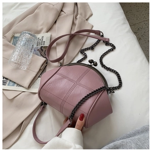 Detail of dusty rose quilted shell bag with vintage metal clasp and chain strap