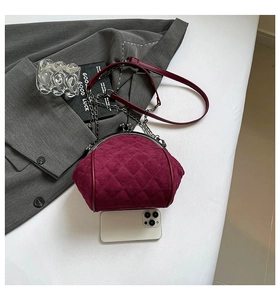 Size comparison of burgundy velvet frame bag next to a smartphone with metal chain