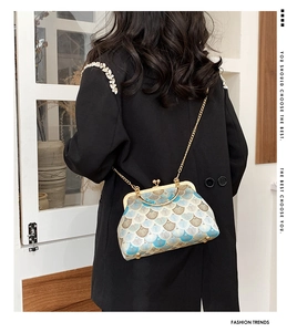 Detail of vintage jacquard pattern on fan-shaped handbag with golden metal frame