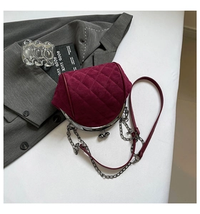 Macro detail of wine red quilted suede bag with silver vintage kiss-lock frame
