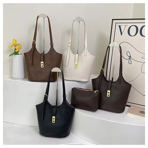 Macro detail of textured faux leather tote bags with gold square hardware and small pouches