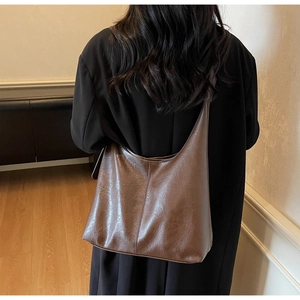 Deep coffee vintage hobo bag shown on shoulder in a modern minimalist indoor setting