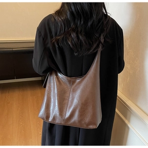 Detailed view of the vintage brown faux leather Hobo bag with textured surface on shoulder