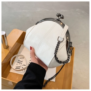 Detail of white PU leather shell bag showing lychee texture and metal clasp closure
