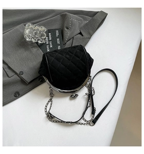 Detail of black quilted suede bag with vintage silver metal frame and chain strap