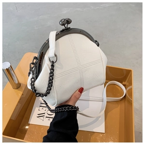 Detail of white shell crossbody bag with retro metal clasp and chain strap features