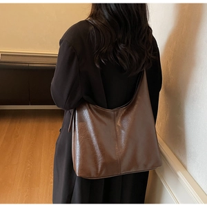 Detail view showing large brown PU leather tote bag with elegant soft texture and stitching