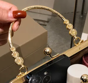 Detail of elegant gold circular handle and spherical metal clasp on a vintage handbag