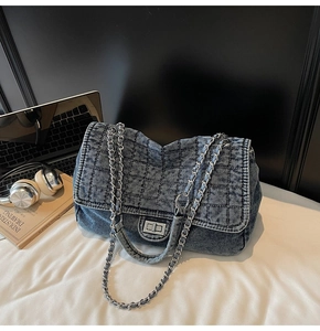 Detail of vintage denim crossbody bag with diamond quilting and silver twist lock