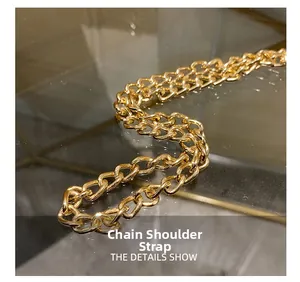 Detailed macro shot of the polished gold metal chain shoulder strap for handbags