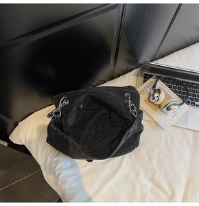 Detail view of the black denim bag interior showing the main compartment and zip pocket