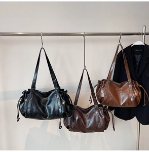 Détail de grands sacs bandoulière en cuir PU en noir, marron foncé et couleur caramel