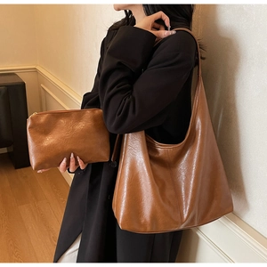 Detail shot of the brown soft leather tote bag with matching smaller zipper pouch
