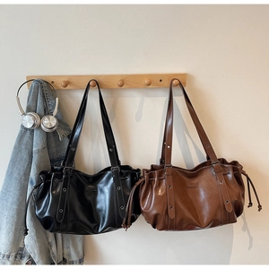 Grands sacs cabas en similicuir noir et marron de style vintage suspendus dans un salon