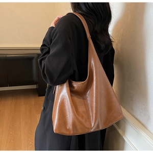 Detail of caramel brown oversized tote bag showing soft leather texture and stitch craft