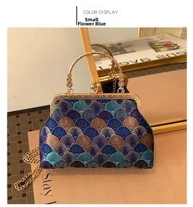 Detail of blue Chinese cheongsam handbag with gold handle and fan pattern embroidery