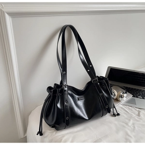 Détail du sac bandoulière noir brillant en cuir PU avec cordon et œillets métalliques
