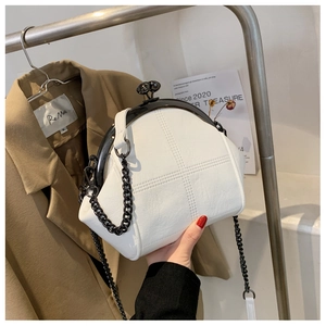 Detailed view of white vintage shell bag with black metal ball clasp and quilted leather