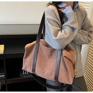 Detail of large canvas tote bag in brown with leather straps on a female model shoulder
