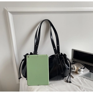 Détail du grand sac cabas noir en similicuir montrant la capacité avec une tablette