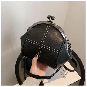 Detail showing high-quality black kiss-lock bag with white cross-stitching and chain strap