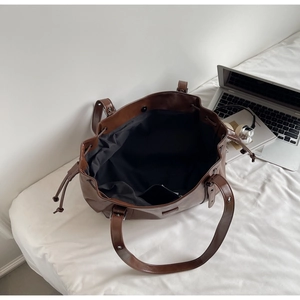 Vue de dessus d'un grand sac cabas en similicuir marron avec doublure et cordon latéral