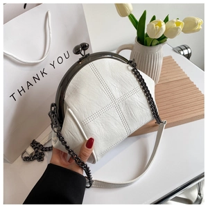 Macro shot of the white quilted shell bag with vintage metal kiss-lock frame and chain