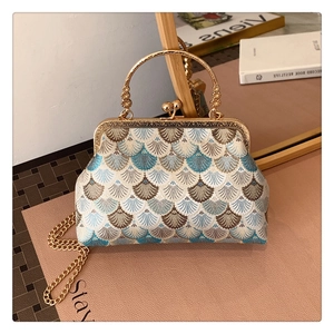 Close-up of vintage jacquard pattern and metal cutout handle on the elegant handbag