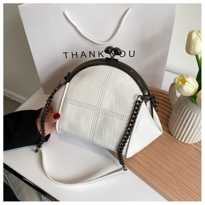 Detail of white leather crossbody bag with shell frame and black metal chain strap