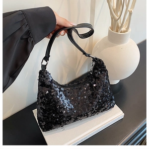 Detailed overhead shot of black sequin shoulder bag with metallic buckle and floral accents