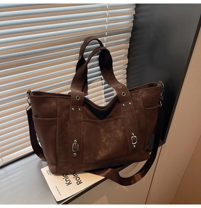 Close-up of deep brown vintage tote bag showing matte texture and silver rivet details