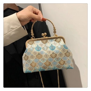 Detail of vintage embroidered shell pattern handbag with gold metal kiss-lock and handle