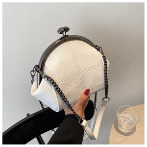 Detail of white vintage shell bag featuring metal clasp and textured faux leather finish