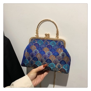 Detailed close-up of navy blue embroidered silk evening bag with golden round handle