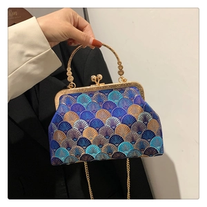 Detail of vintage embroidered handbag with gold metal ring handle and clasp