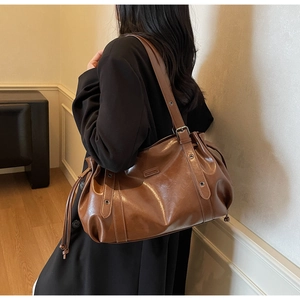 Détail d'un sac bandoulière en similicuir marron avec cordon et bandoulière à œillets