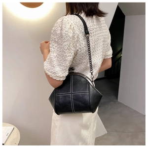 Detail of a black retro doctor-style crossbody bag with white cross stitching on back