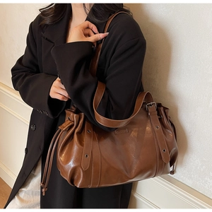 Sac bandoulière marron en cuir avec texture plissée à cordon et boucles métalliques réglables