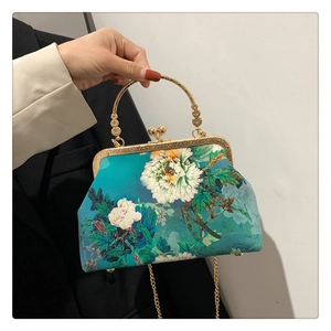 Detail of vintage floral print handbag with gold metal clasp and beaded handle