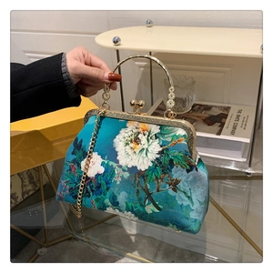 Detail of peacock green satin handbag with white peony floral print and retro metal frame