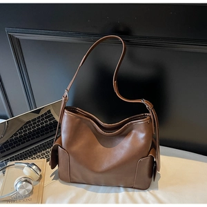 Detail of dark brown leather tote bag with side pocket and adjustable wide strap