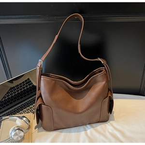 Close-up of brown PU leather tote bag with side pocket and adjustable strap for commuting